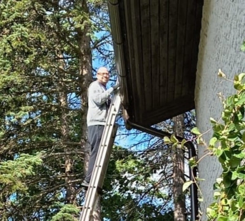 Kyösti cleaning the rain gutter of his house